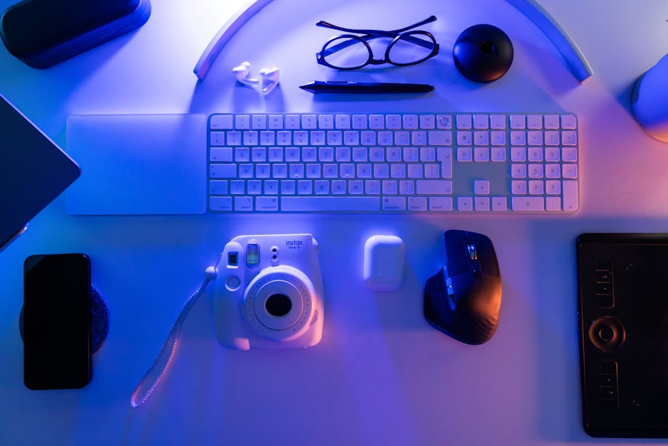 Overhead view of a stylish desk setup featuring essential tech gadgets in a neon glow.